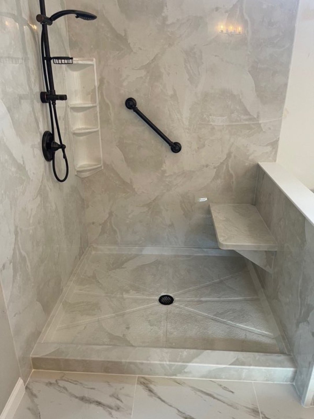 Walk-in shower with a built-in bench, handheld shower, and matte black grab bars