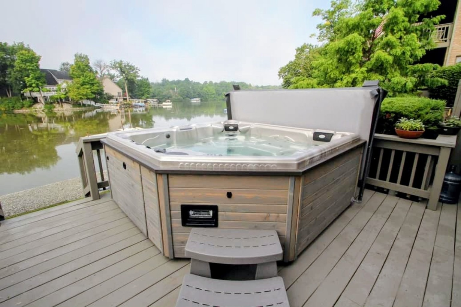 Hot tub on an outdoor deck beside a lake